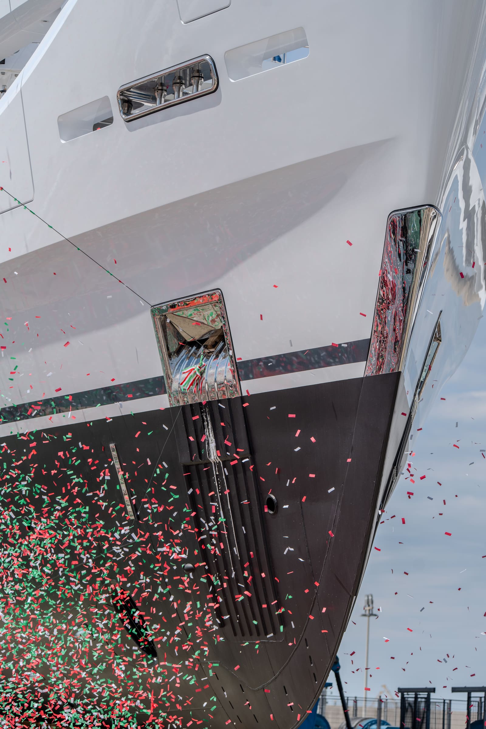 Confetti falling across the hull of a superyacht at her launch ceremony