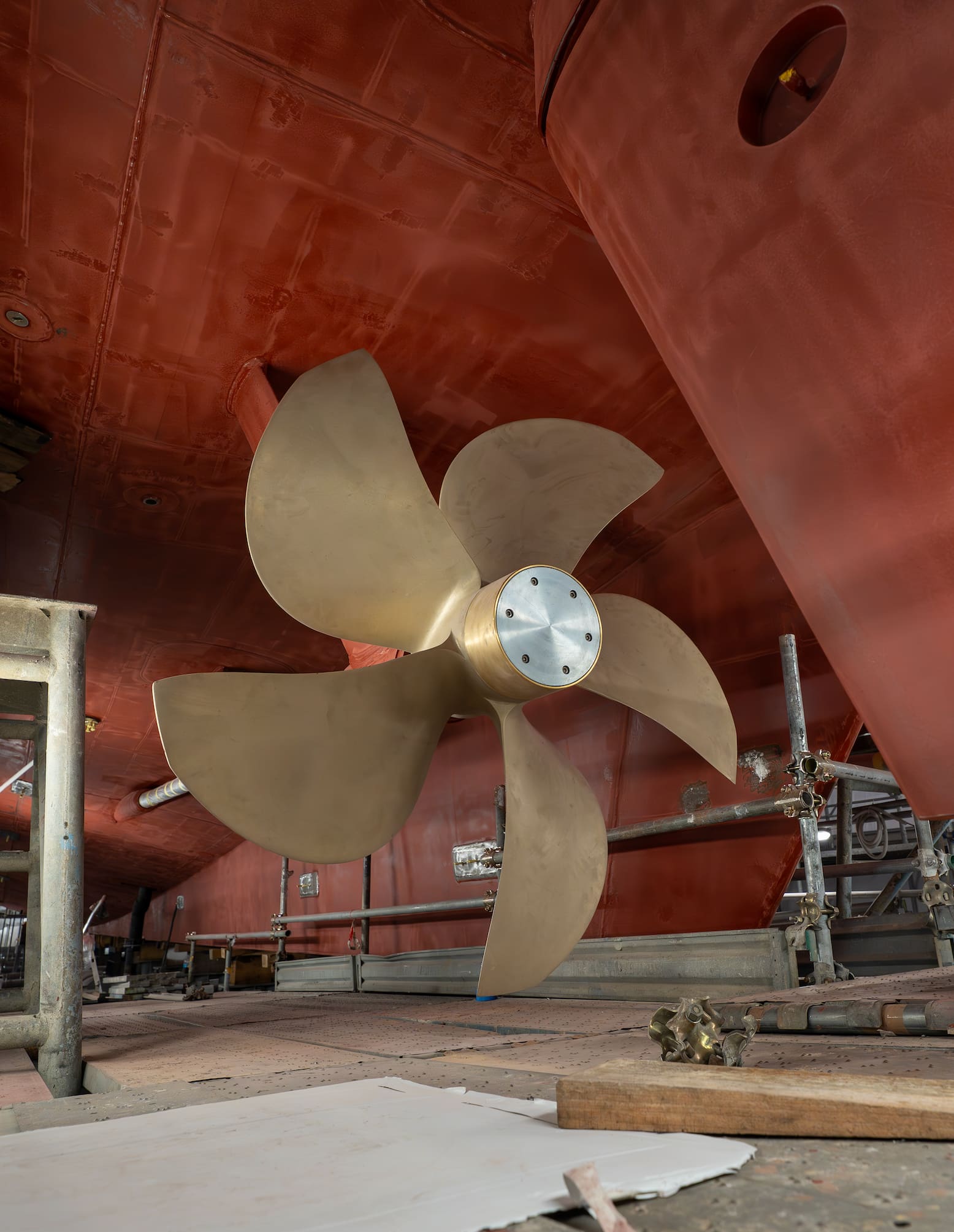 A five-blade bronze propeller under a yacht hull during a refit