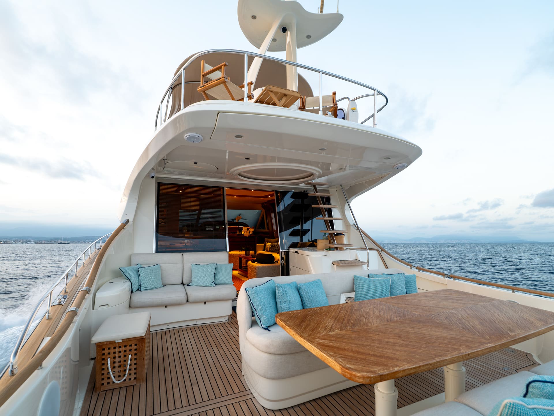 Mochi Craft Dolphin 74 Contango, aft deck at dusk with the salon lit behind
